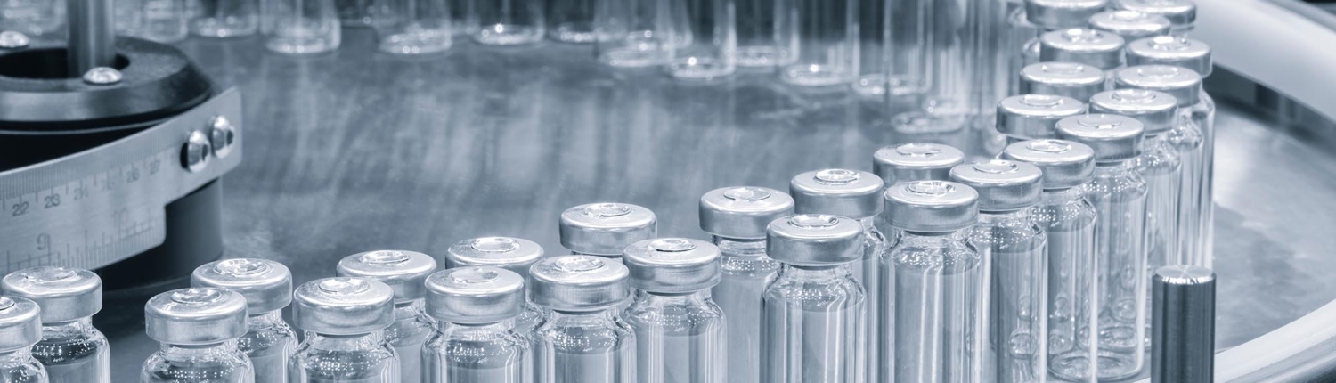 Side view of medical vials in production