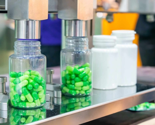 Medicine bottles being filled on assembly line in factory